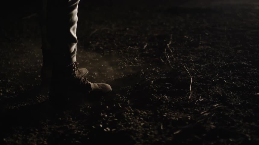 Someone wearing boots and standing on smoky ground