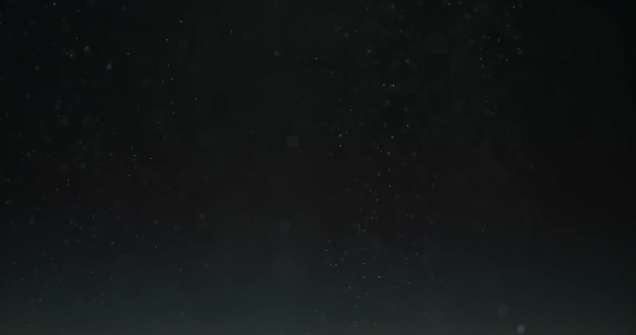 Small air bubbles rising up on clear liquid with dark background
