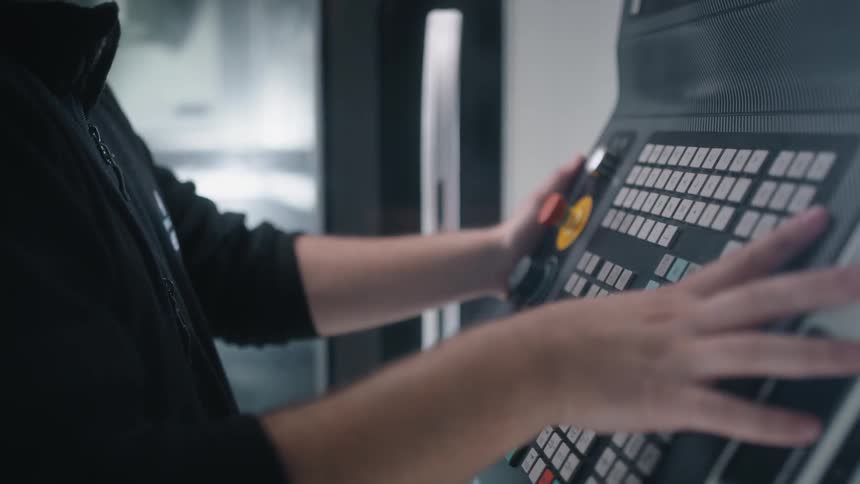 A man is operating the control board of a machine