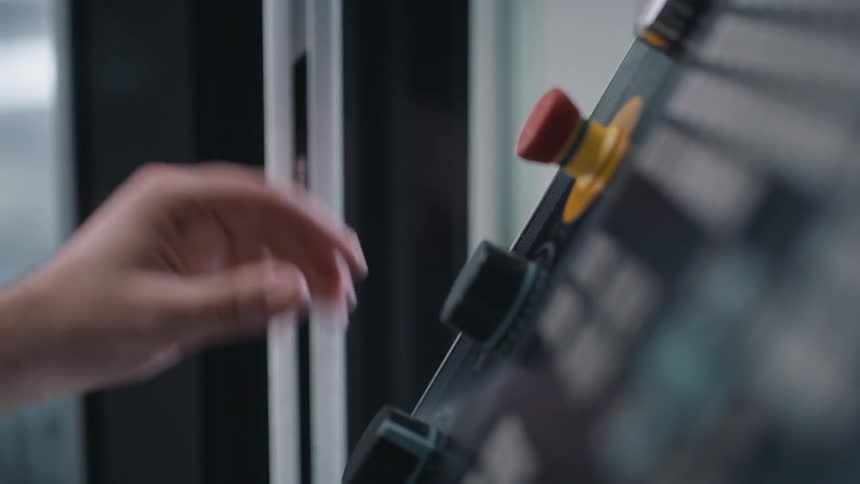 A person turns a knob on a control panel and opens a door