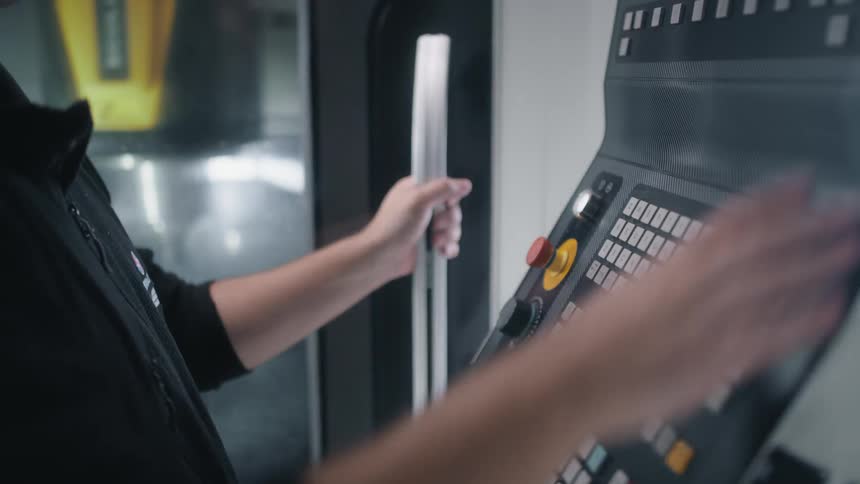 A man pushes buttons on a large control panel