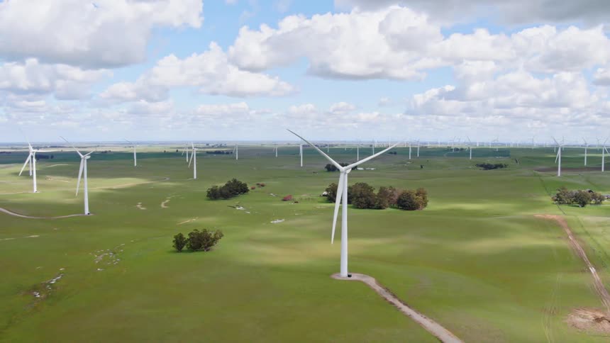 Wind turbines slowly turn on a windmill farm
