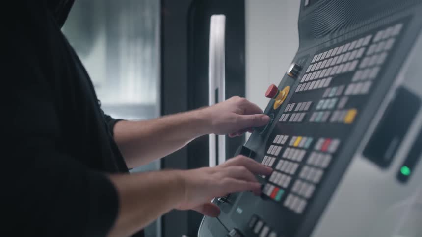 A man is pushing buttons on a control interface
