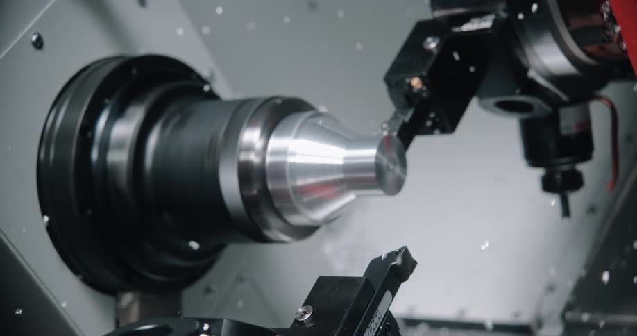A metal tool shaper shapes a metal object on a lathe