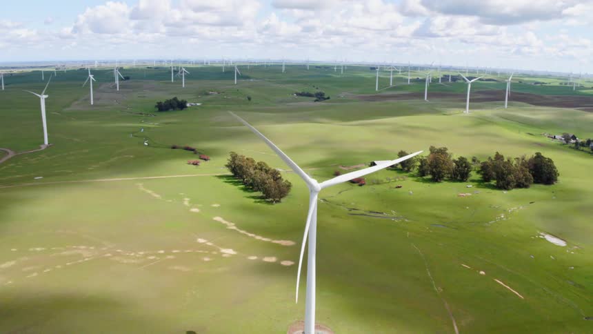 Aerial view of wind farm on a green grass field