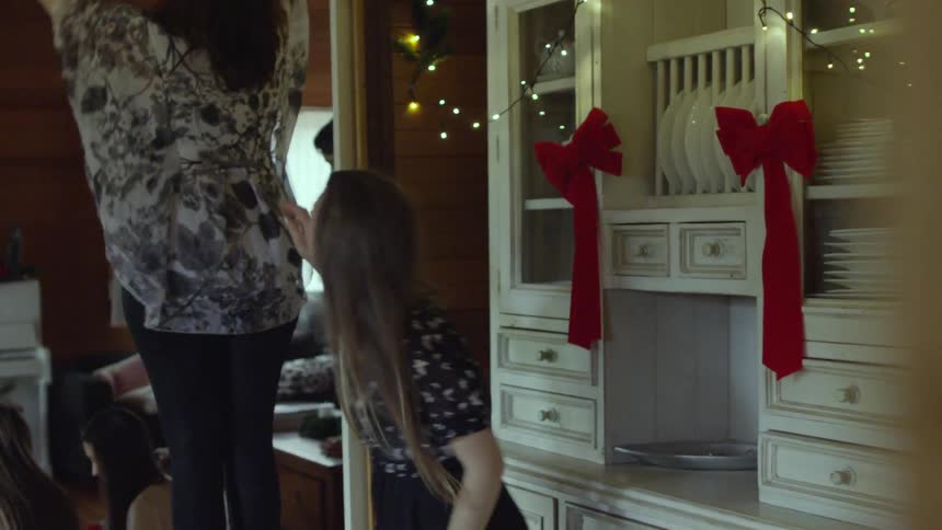 A family is putting christmas lights up in a home