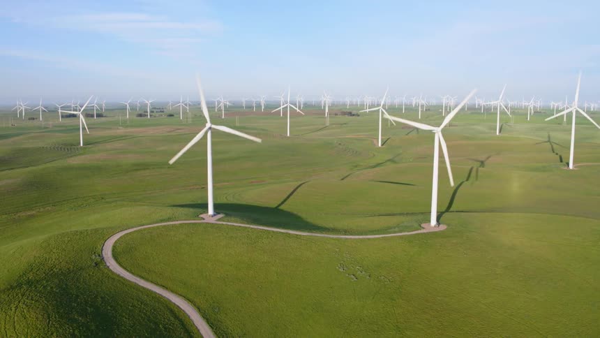 Spinning wind turbines in a hilly wind farm during the day