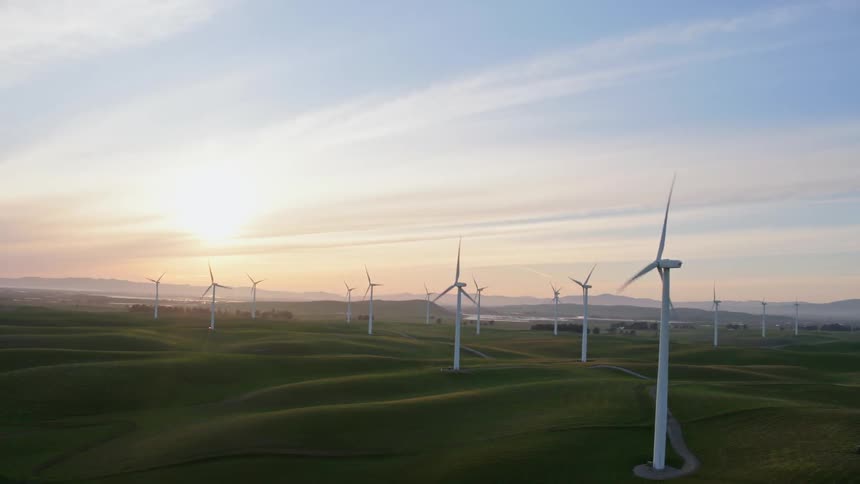 Windmills are powering the farm field at morning