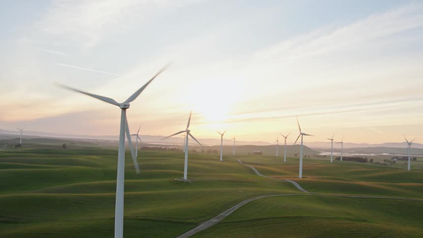 Aerial view of wind turbines in a field at sunset