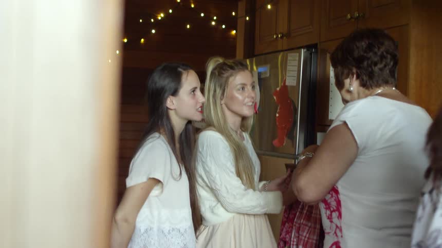 A group of women in a kitchen talking and laughing