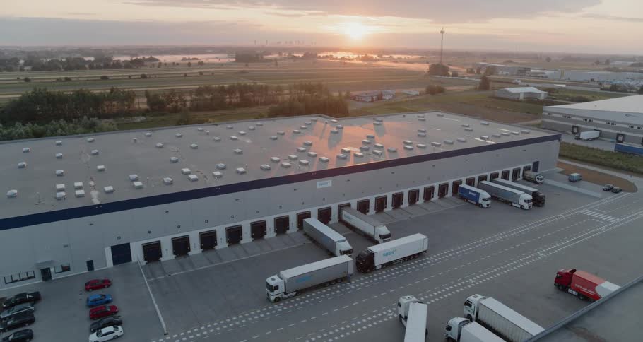 A truck pulling into the loading area of a warehouse
