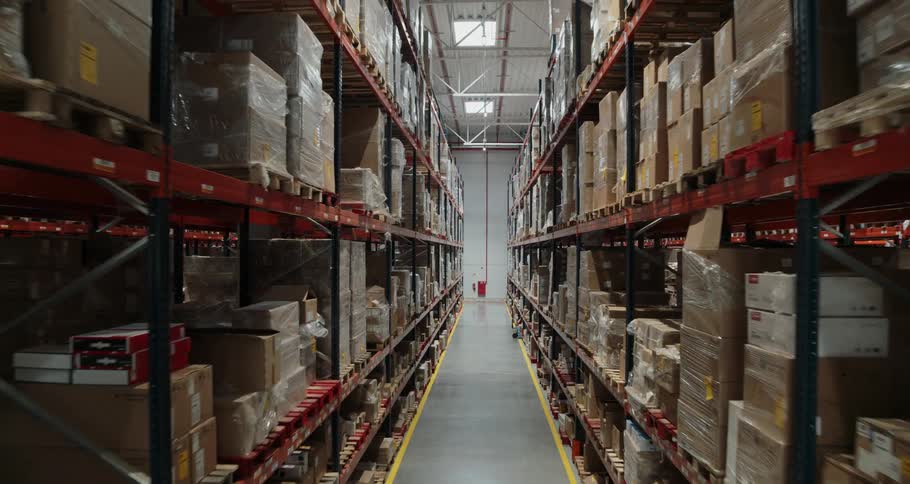 Plastic wrapped boxes on metal shelves in a warehouse