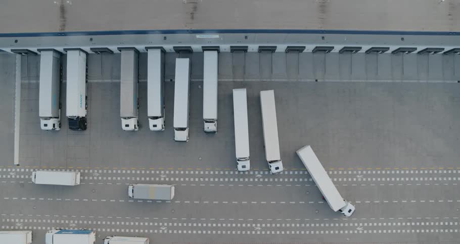 Freight trucks pulling out of loading docks at a warehouse