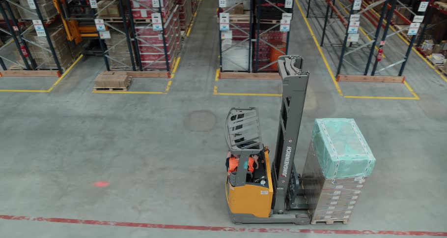 A forklift carries some boxes in the warehouse