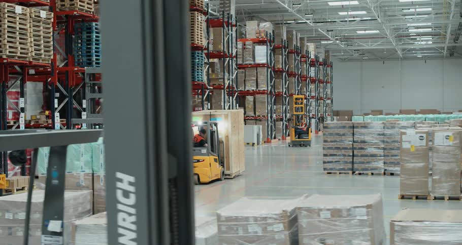 Fork lifts move in a warehouse