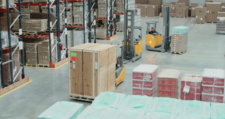 Warehouse workers move pallets with forklifts