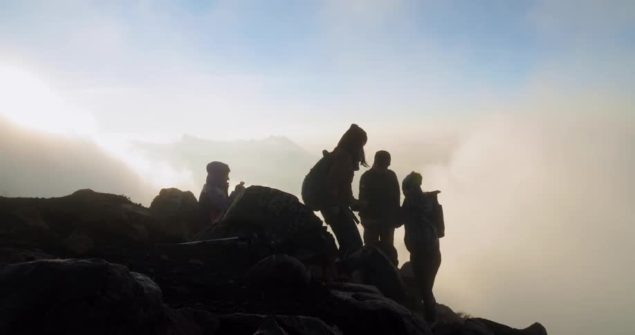 Campers set up on a slope as clouds float by