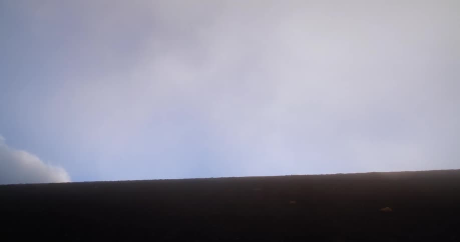 Clouds pass over the top of sand dunes