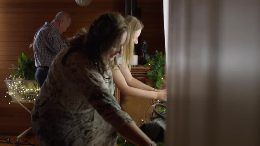 People are talking and placing christmas decorations in a home