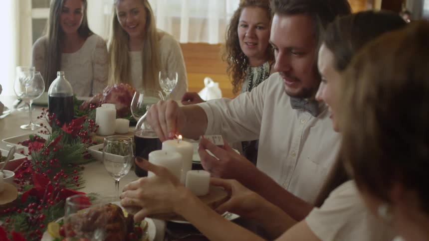 A family watches as a candle centerpiece is lit