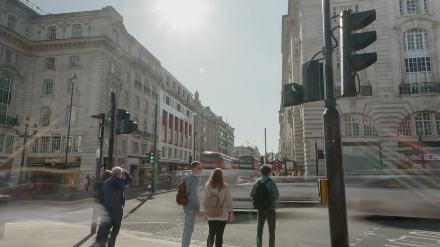 A busy intersection in a downtown is full of vehicle traffic as well as many pedestrians