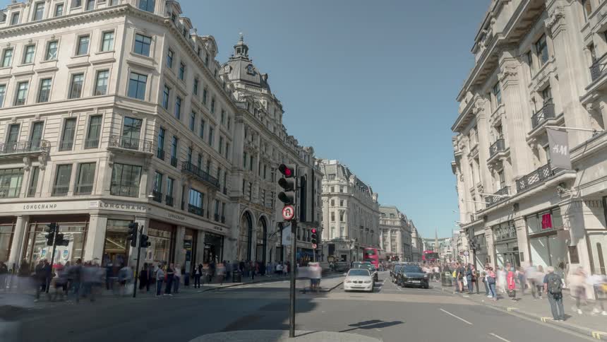 A city street with vehicles people and buildings in the background
