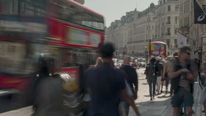 Hundreds of people travel a city sidewalk