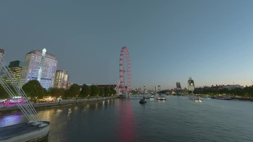 A bridge over a river with boats and a ferris wheel