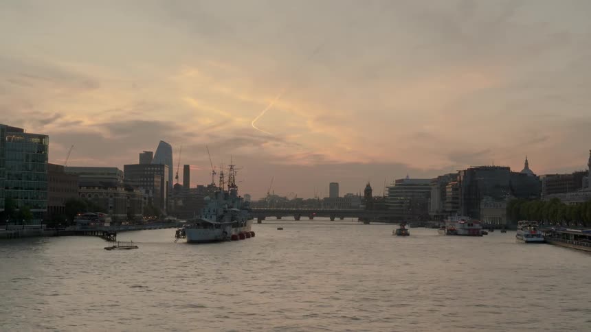 The boats move around in the river by the city