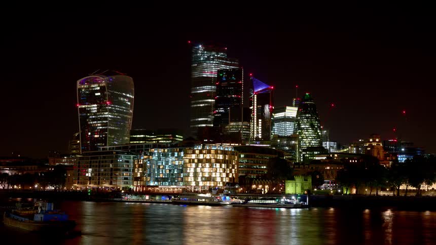 A river at night with boats and the city skyline in the background