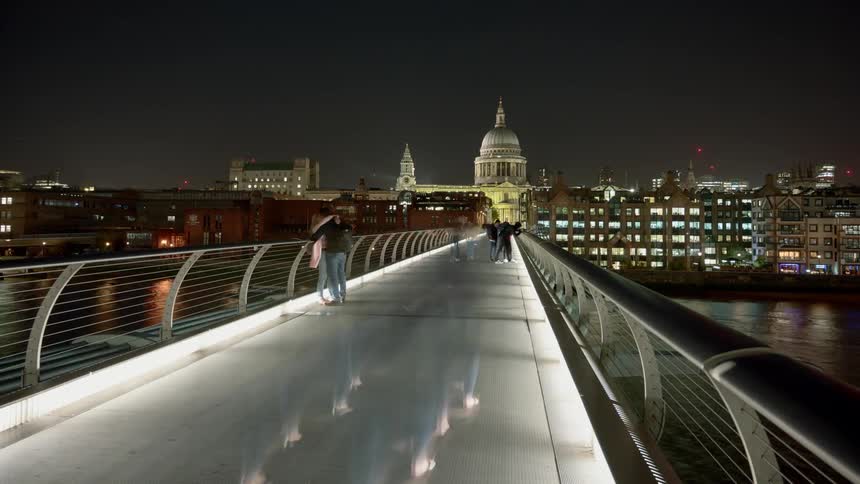 Pedestrians on the millennium bridge with st pauls cathedral in the background