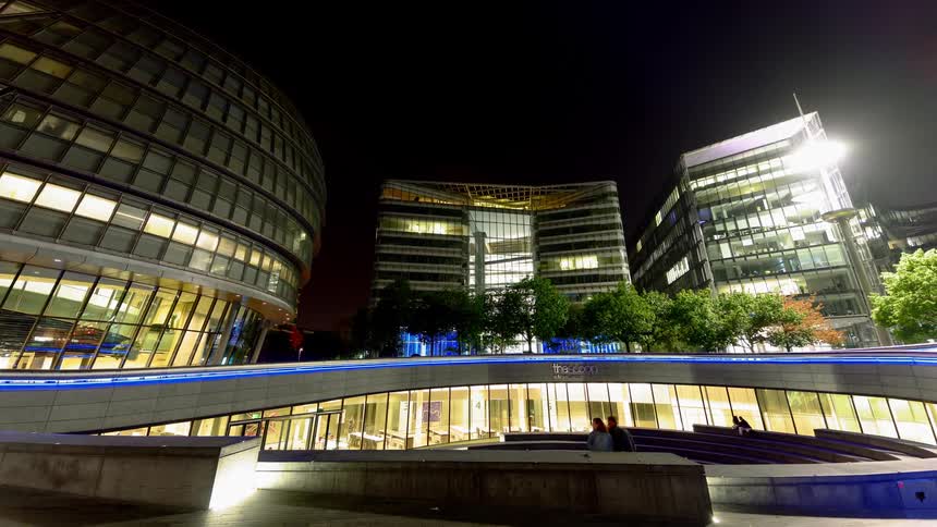 People walk by large buildings