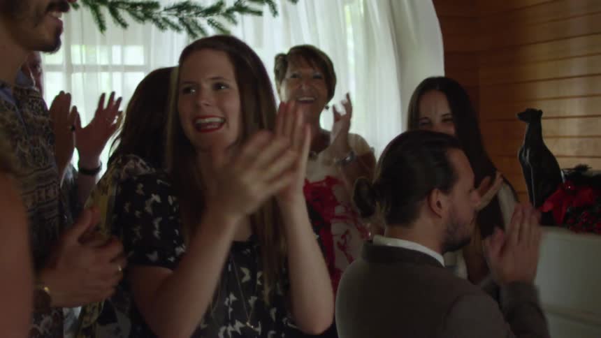 A group of people are clapping inside of a home