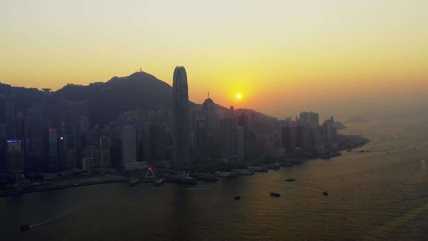 Skyline of the city with tall buildings and skyscrapers next to the ocean at sunset