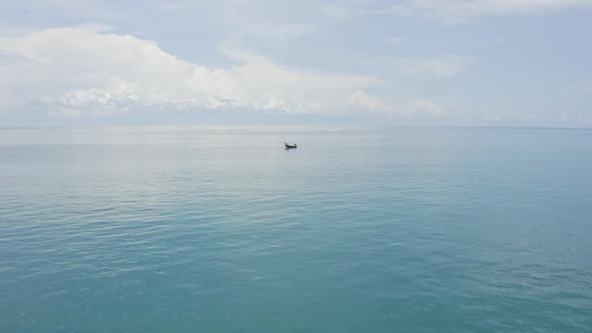 A small fishing boat in the middle of tropical blue water