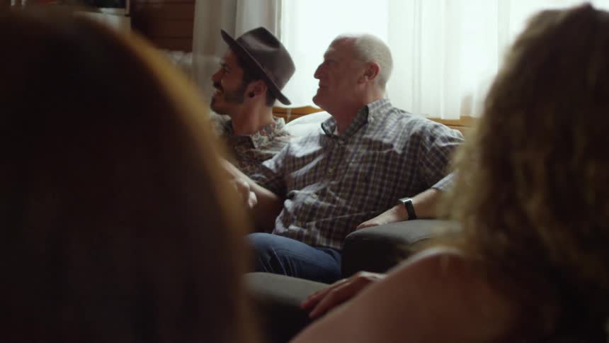 A group of people sing and sway on a couch