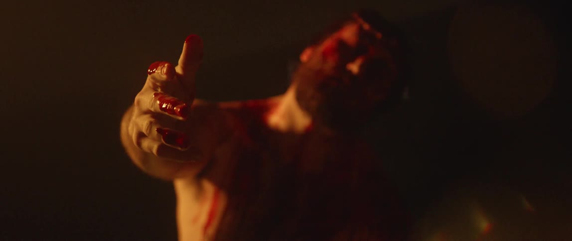 Bearded man reaches out his bloody hand
