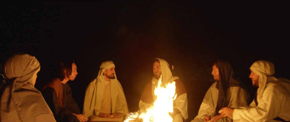 People sit around the campfire together