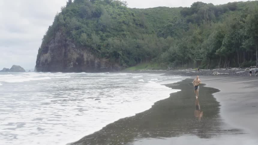 Man running on the shoreline at the beach