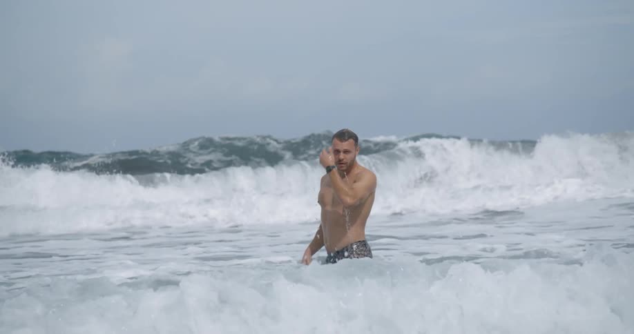 Man swims against the waves in the sea during daylight