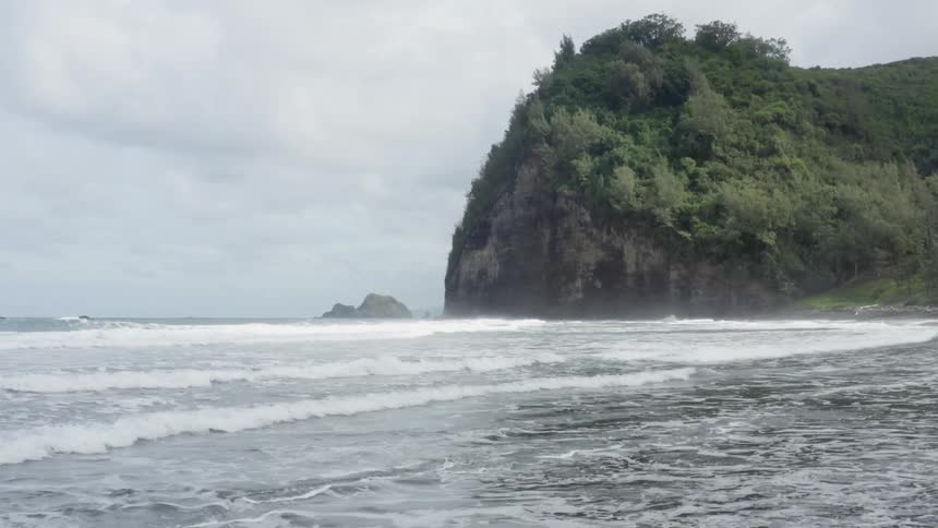 Coastal view of waves crashing the shoreline on a cloudy day