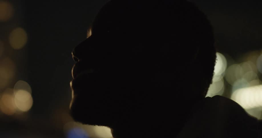 A man is looking up in the night