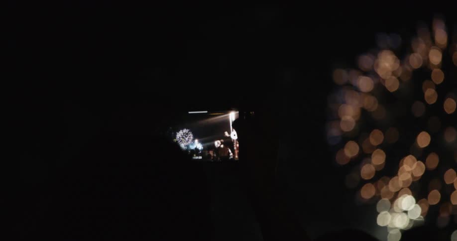 A person is recording fireworks on their cell phone