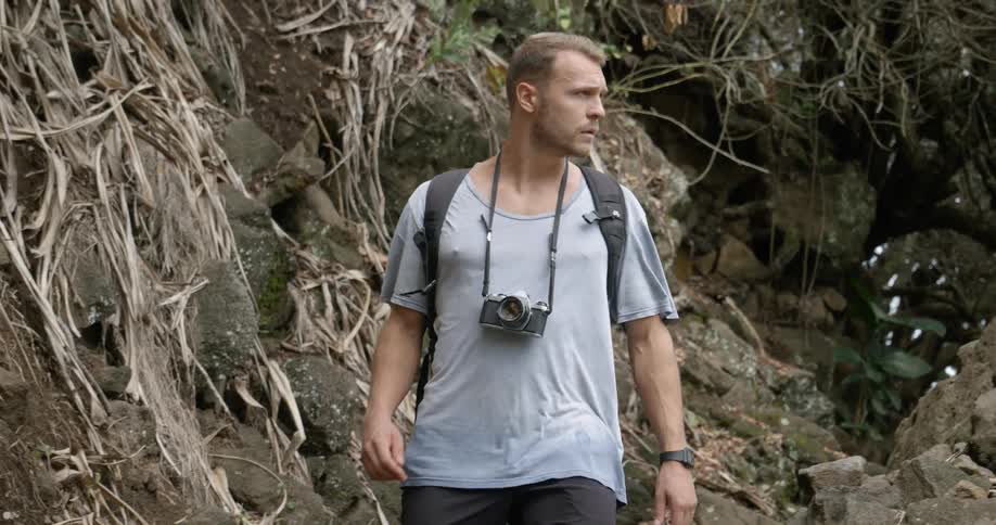 Man wearing a backpack walks in the forest