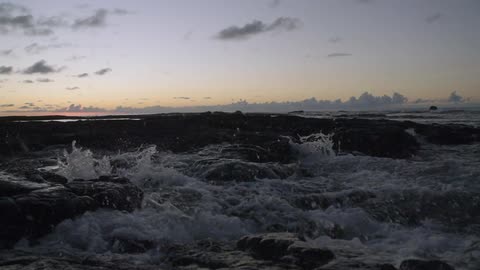 The wave slams against the shore spraying water everywhere