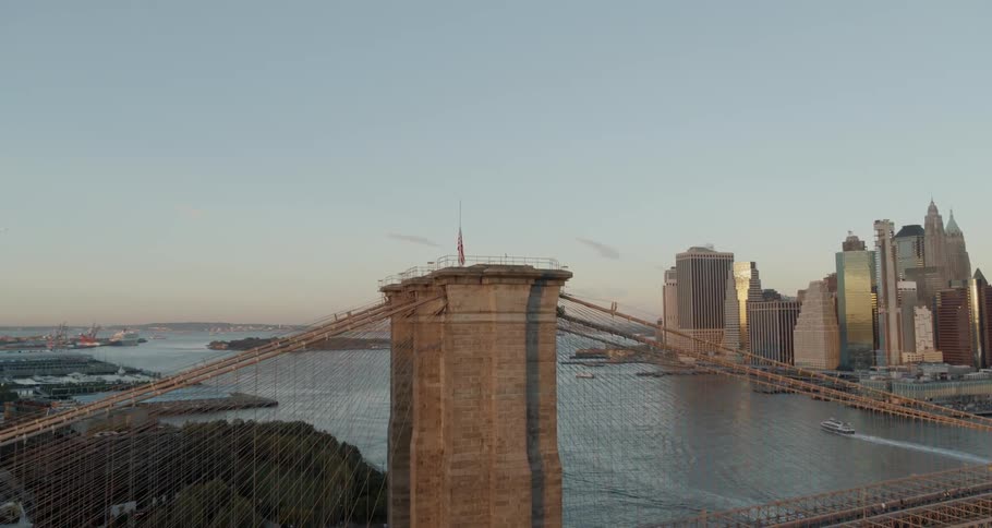 A bridge over a river with a city skyline in the background