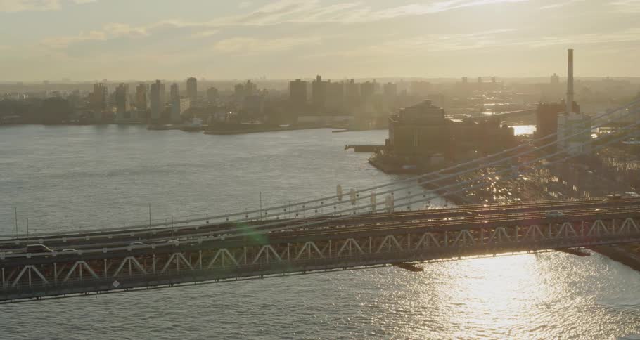 Cars drive across a bridge near a city