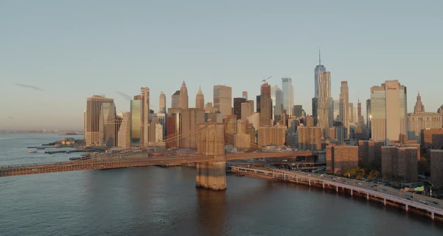 The vehicles travel on the large bridge by the city