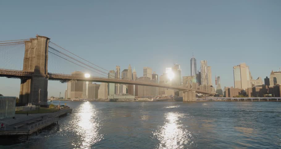 A large bridge connects to a big city across a river