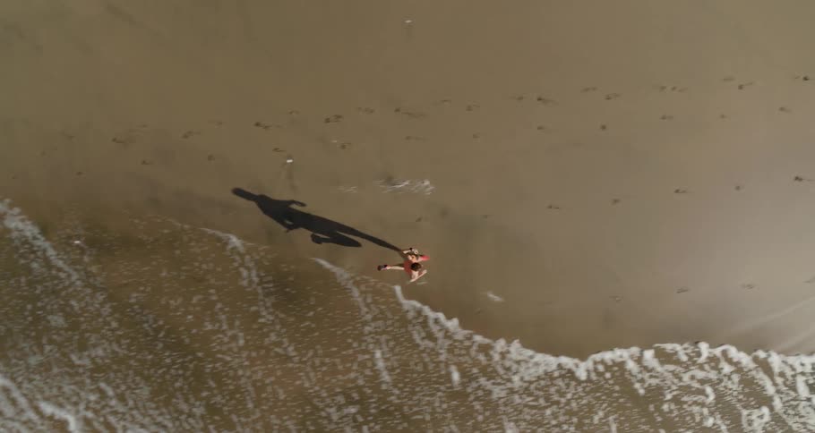 A bird eye view of a man running on the beach